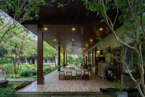a restaurant with tables and chairs on a wooden deck at Amrita Green Retreat in Chaozhou