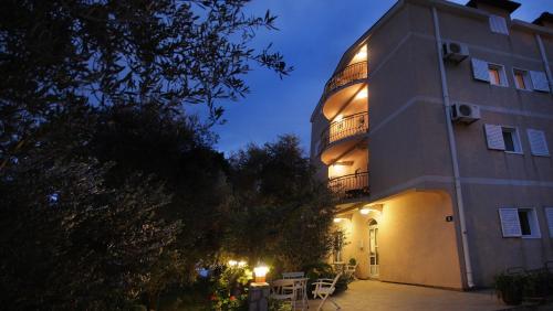 a building with a clock tower at night at Apartments Villa Slavica in Petrovac na Moru