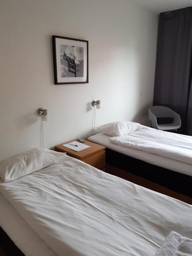 a hotel room with two beds and a picture on the wall at Lilla Hotellet in Eskilstuna