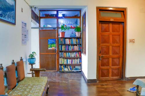 una habitación con una puerta y una estantería llena de libros en kailwood Guest House, en McLeod Ganj