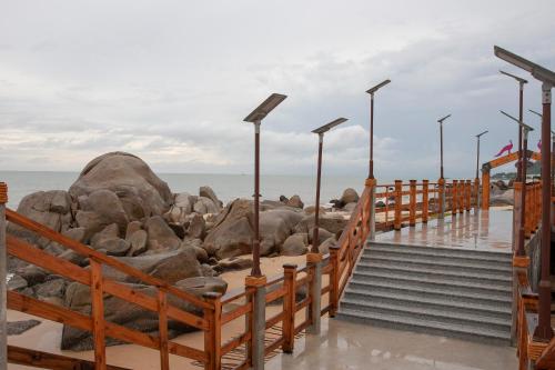 a wooden pier with rocks on the beach at Trân Châu Beach & Resort in Ba Ria