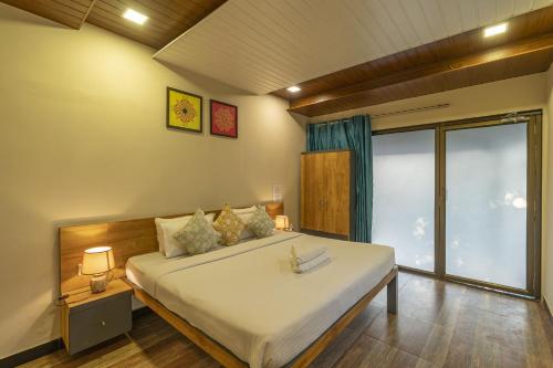 Un dormitorio con una cama grande y una ventana grande. en Zostel Kolad, en Kolād