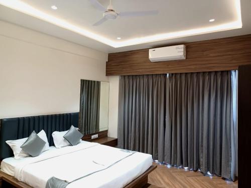 a bedroom with a large bed and a window at Hotel Maharaja in Nashik