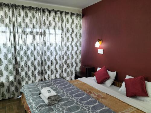 a bedroom with two beds and a window at kailwood Guest House in McLeod Ganj
