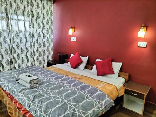 a bedroom with a bed with red walls at kailwood Guest House in McLeod Ganj