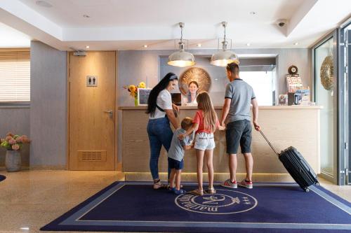 a family standing on a welcome mat in an airport at Hotel Marina Club Old Town View in Gdańsk