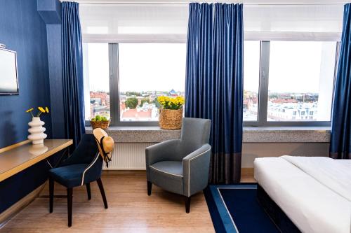 a hotel room with a bed and two chairs and a desk at Hotel Marina Club Old Town View in Gdańsk