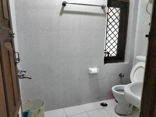 a bathroom with a toilet and a sink at kailwood Guest House in McLeod Ganj