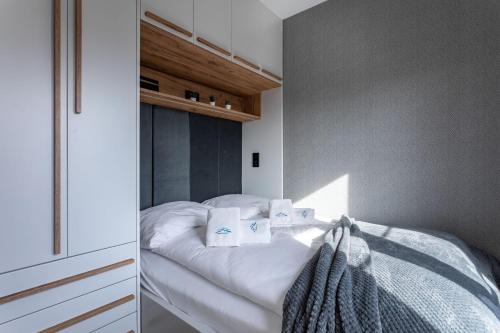 - une chambre avec un lit doté de draps et d'oreillers blancs dans l'établissement Green Park Resort D5- z dostępem do basenu, sauny, jacuzzi, siłowni, à Szklarska Poręba