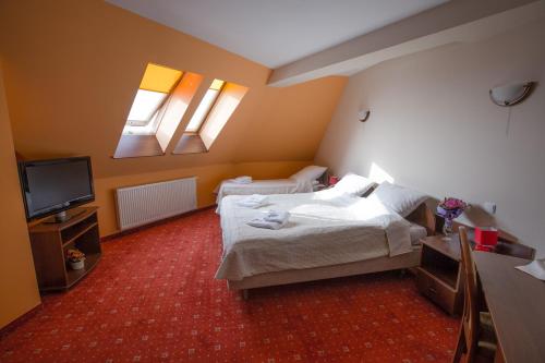 ノヴィ・タルクにあるSkalny Dworekのベッド2台とテレビが備わるホテルルームです。