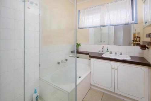 y baño con ducha acristalada y lavamanos. en Beautiful Family home, en Doveton