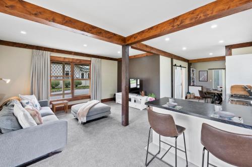 a kitchen and living room with a couch and a table at The Olde Store - Hunua Holiday Home in Hunua