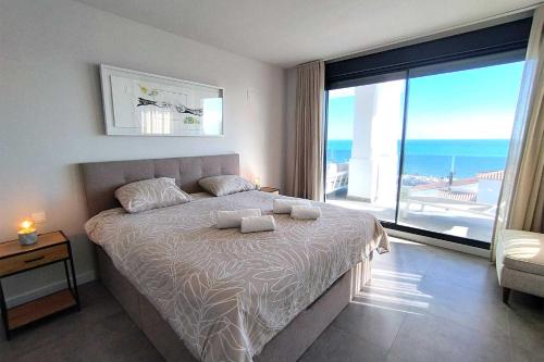 ein Schlafzimmer mit einem Bett mit Blick auf das Meer in der Unterkunft Blue Suites in Manilva