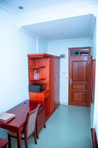 a room with a wooden desk and a wooden door at Greenlight Hotel in Dar es Salaam