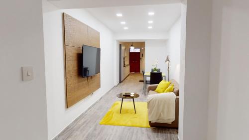 a living room with a couch and a tv on a wall at Central Valletta - 1 Bedroom maisonnette in Valletta