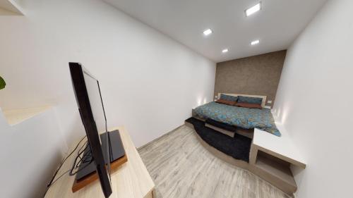 a bedroom with a bed and a tv in a room at Central Valletta - 1 Bedroom maisonnette in Valletta