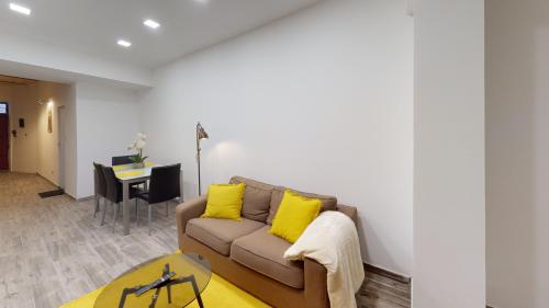 a living room with a couch and a table at Central Valletta - 1 Bedroom maisonnette in Valletta