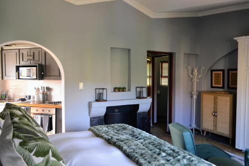 a living room with a bed and a kitchen at Cherry Grove 2 in Dullstroom