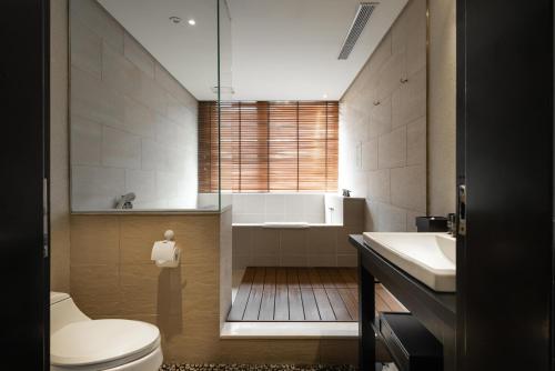 La salle de bains est pourvue de toilettes, d'une baignoire et d'un lavabo. dans l'établissement Beitou Sweet Me Hot Spring Resort, à Taipei