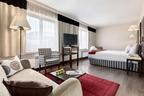 ブリュッセルにあるNH ブリュッセル グランプラス アレンベルグのベッドとソファ付きのホテルルーム