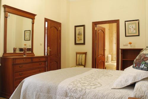 Schlafzimmer mit einem Bett, einer Kommode und einem Spiegel in der Unterkunft Casa del Sol in Cieza
