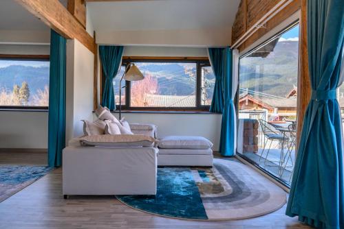 a living room with a couch and a large window at 玉龙白沙普宿客栈 in Lijiang