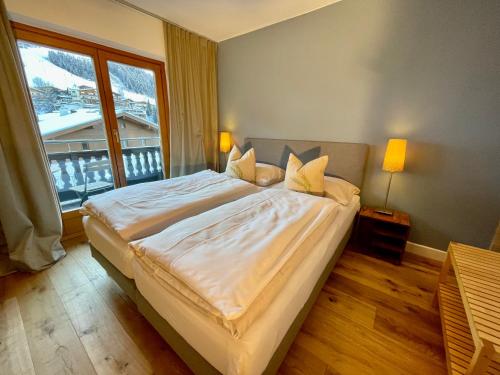 sypialnia z dużym łóżkiem i dużym oknem w obiekcie Chalet Augustine Hinterglemm Zentrum w Saalbach Hinterglemm