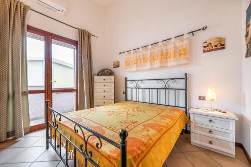 a bedroom with a bed and a window at Maya in Villasimius