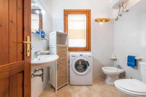 a bathroom with a washing machine and a sink at Maya in Villasimius