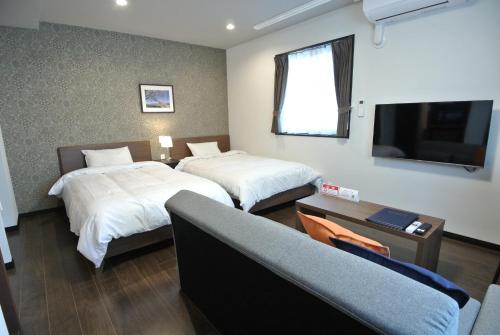 a hotel room with two beds and a flat screen tv at SA Inn Ina Nice Road - Vacation STAY 87470v in Ina