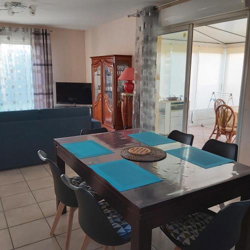 - un salon avec une table à manger et des chaises dans l'établissement COSYMEDOC, à Le Pian-Médoc