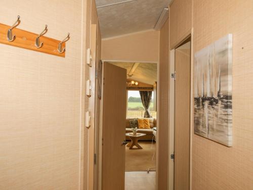 a hallway with a door to a room with a living room at Mountain View Lodge in Holyhead