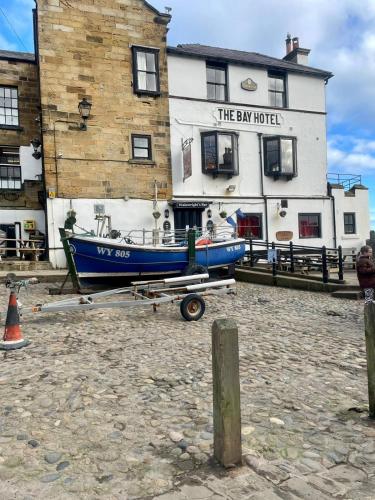 a blue boat on a trailer in front of a building at Robin Hood's Bay Coastguard's Cottage with a View in Robin Hood's Bay