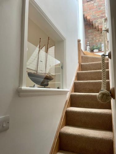 a staircase with a mirror with a boat in it at Robin Hood's Bay Coastguard's Cottage with a View in Robin Hood's Bay
