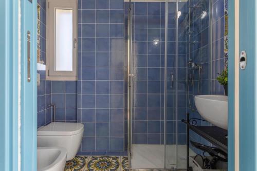 ein blau gefliestes Bad mit WC und Waschbecken in der Unterkunft Virgilio - Con servizio spiaggia - Narramondo Villas in Tortoreto Lido