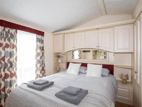 a bedroom with a bed with two towels on it at Mountain View Lodge 2 in Holyhead