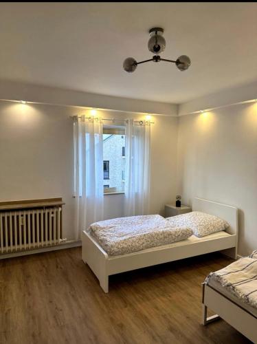 um quarto branco com uma cama e uma janela em Schöne Wohnung nahe Köln em Colônia