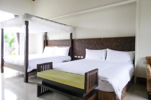 2 camas en una habitación con sábanas blancas en 艸祭莊園 en Pi-tzu-t'ou