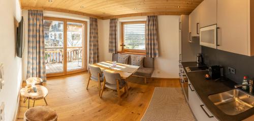 a kitchen and dining room with a wooden floor and a table at Madlhof in Himmelreich