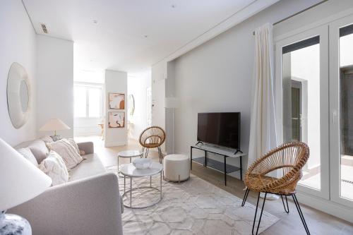 uma sala de estar com um sofá e uma televisão em Palafox Design - Darya Living em Madrid