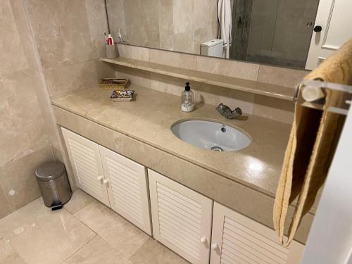 uma casa de banho com um lavatório e um espelho em Apartamento Puerto Sotogrande Marina em Sotogrande