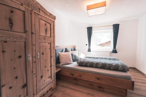 a bedroom with a bed and a large wooden cabinet at Appartement Reichholf in Bramberg am Wildkogel