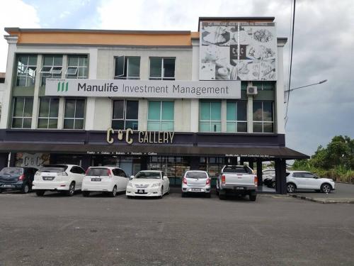 a building with cars parked in a parking lot at Sibu Q1 Homestay -3 Rooms 4 Beds in Sibu