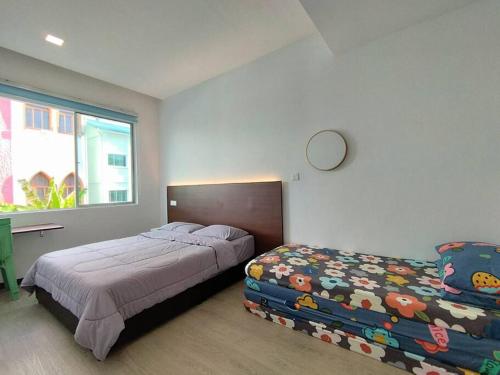 een slaapkamer met 2 bedden en een raam bij Queensway ONE Homestay 10Pax 3Rooms in Sibu