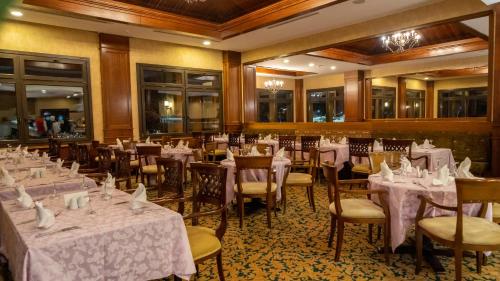 a restaurant with tables and chairs with white table cloth at Duja Chalet Ski Center in Sarıkamıs