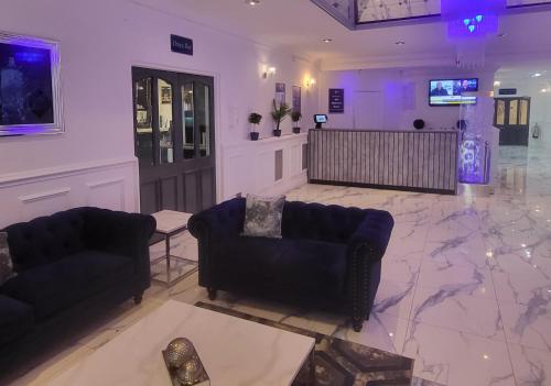 a living room with two couches and a television at The Hillcrest Hotel in Widnes