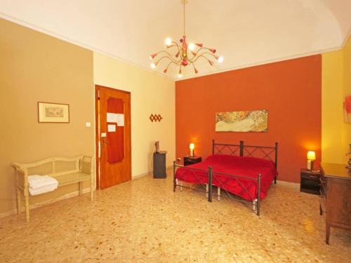 1 dormitorio con cama roja y lámpara de araña en Piccadilly House, en Catania