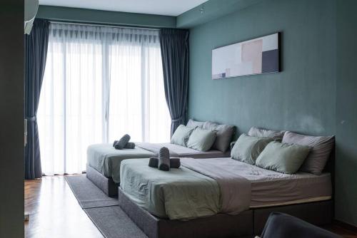 a bedroom with two beds and a large window at Deluxe Seaview Suite Twin Bed by The Only Bnb in Tanjong Tokong