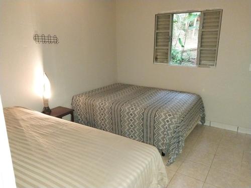 1 dormitorio con 2 camas y ventana en Linda Casa de Campo Sitio Chácara em Campinas, en Campinas