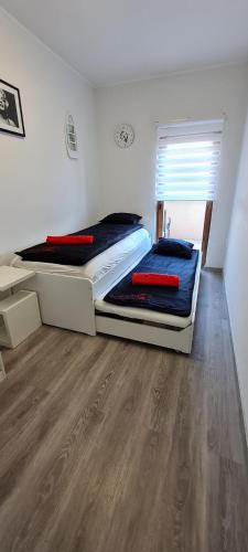 a bedroom with two beds and a wooden floor at IHB-Inter House of Balaton in Zamárdi